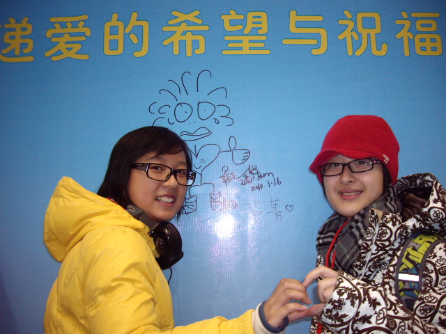 热心参与的一对学生MM在画板前绘画留影